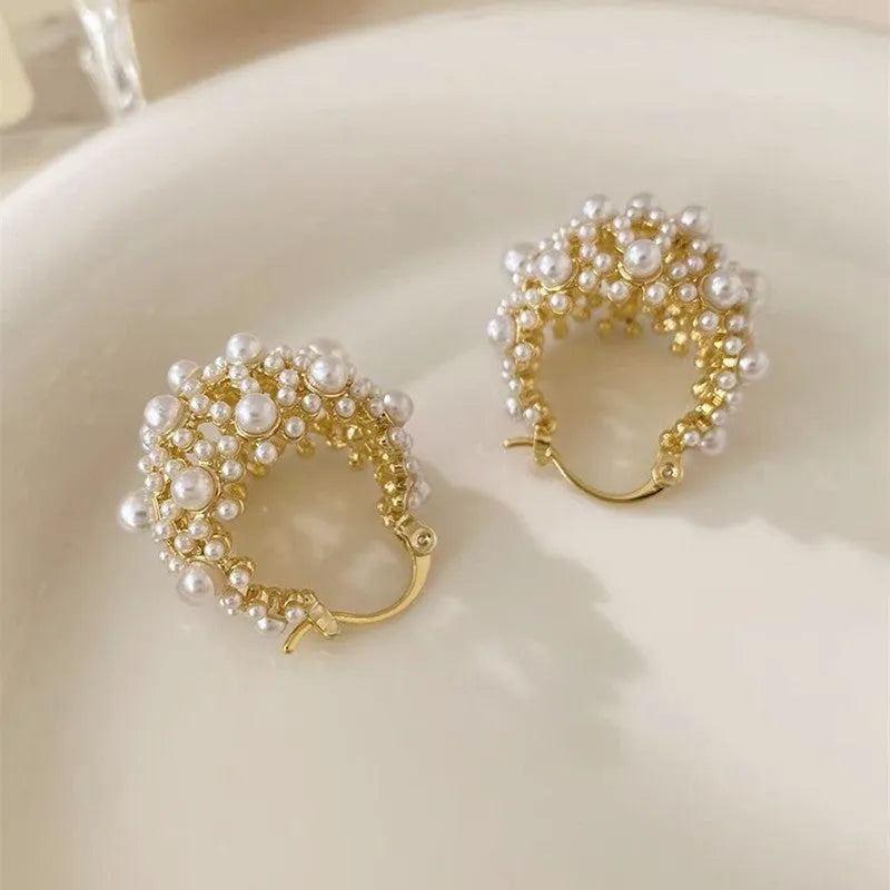 Gold coloured women's flower basket earrings with pearl inlay and small rice-shaped bead details.