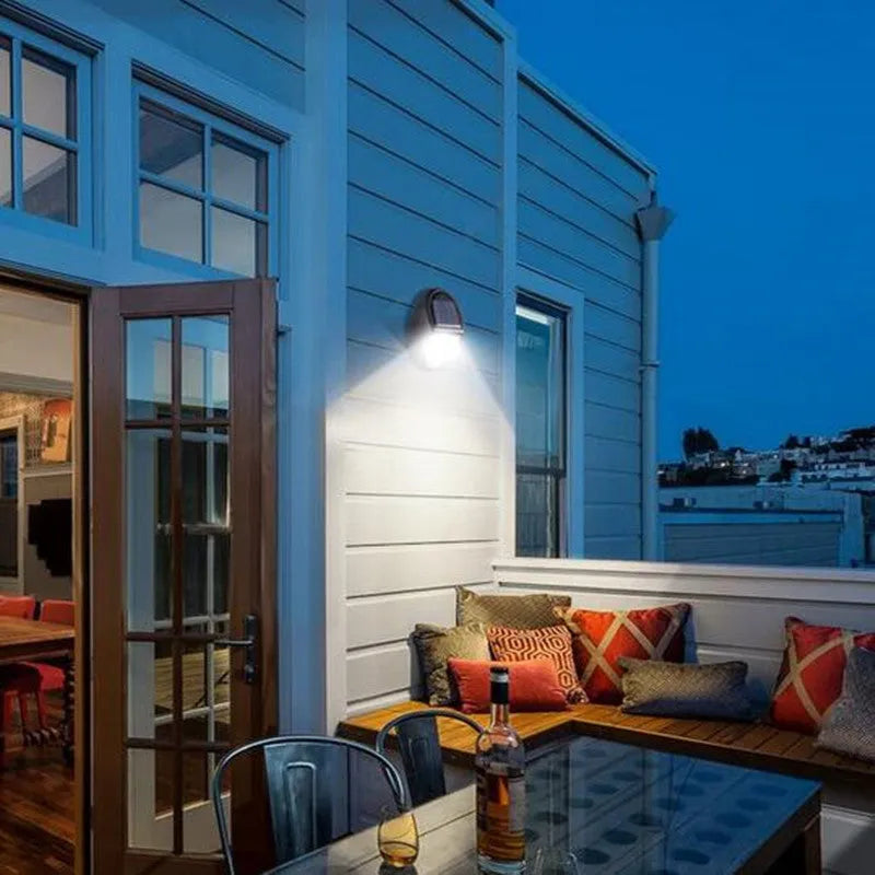Black rectangular solar-powered LED wall light with solar panel on top.