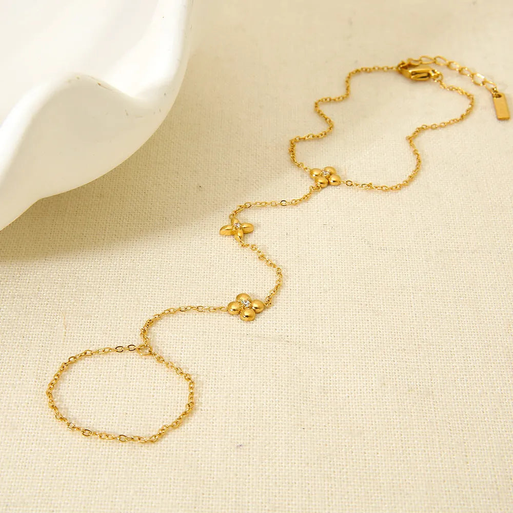 Gold-coloured women's bracelet with floral and eight-pointed star design on stainless steel