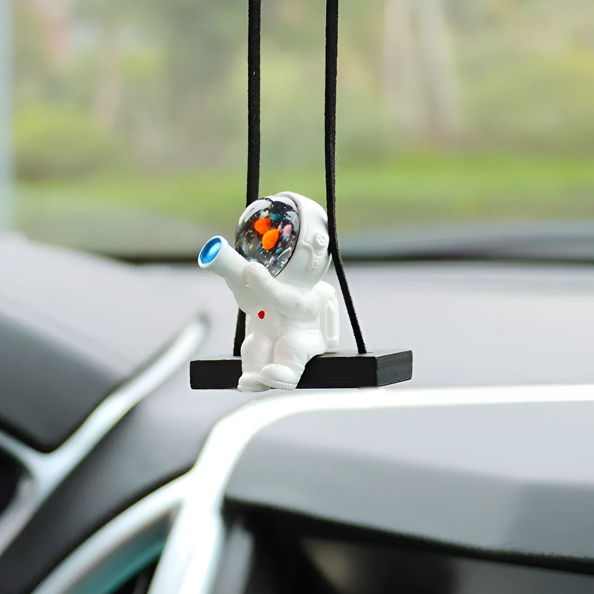Resin astronaut car pendant showing five colour options including telescope and red flag designs