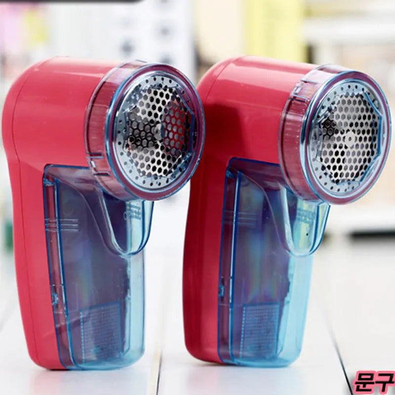 Portable electric clothing lint remover shaver in hand, showing compact size and shaving head.