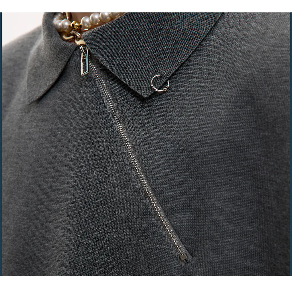 Man modelling a slim-fit black knitted polo shirt with a diagonal oblique zip and lapel collar.