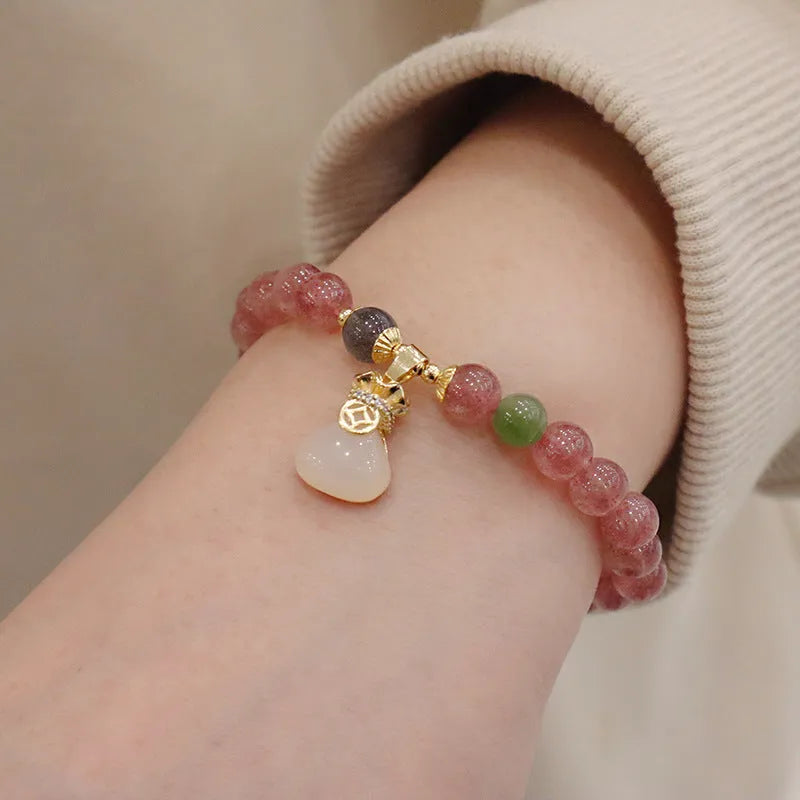 Women's strawberry quartz bracelet with geometric beads, peace buckle closure, and lucky bag charms