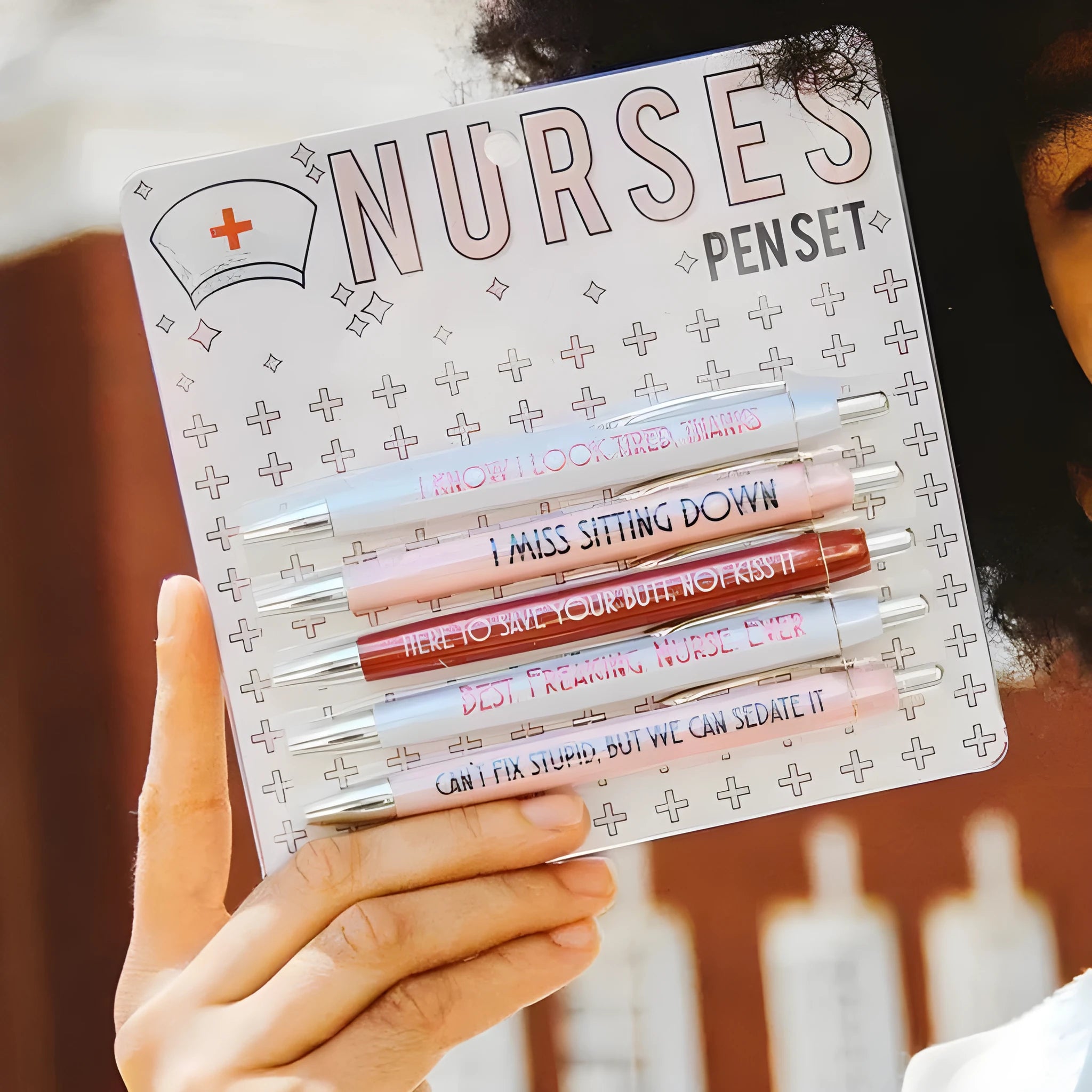 Five nurse-themed retractable ballpoint pens with medical motif designs arranged together
