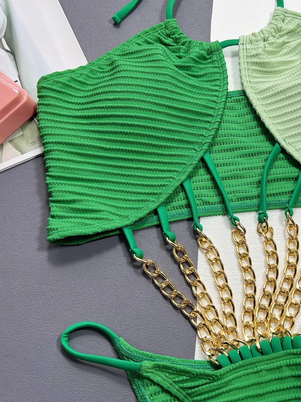Solid green women's one-piece swimsuit with a hollow design on a mannequin.
