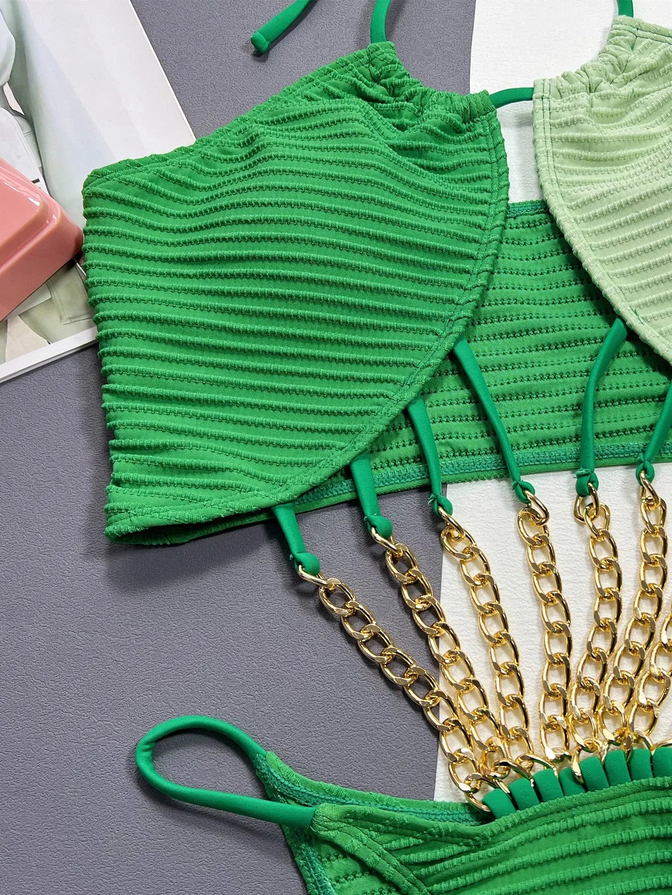 Solid green women's one-piece swimsuit with a hollow design on a mannequin.