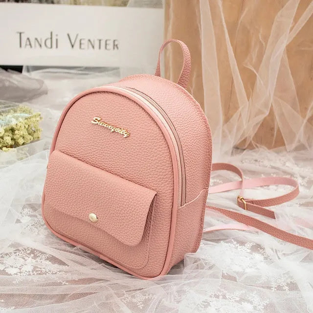 Women's small PU leather backpack shoulder bag in black showing front zipper and compact size