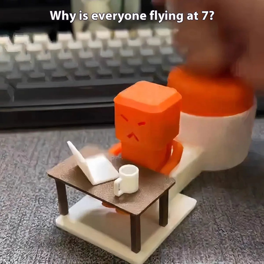 Orange plastic table-turning decompression toy measuring 16cm long on a desk