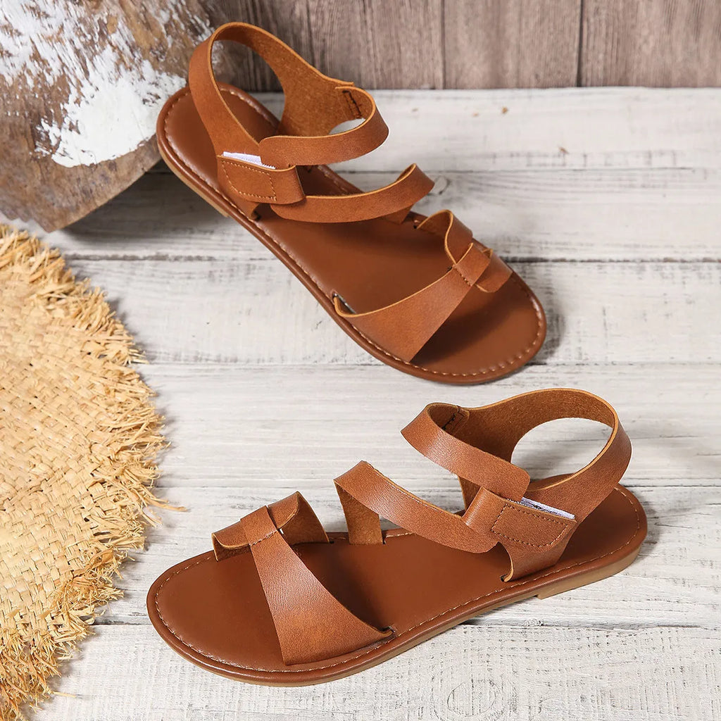 Women's flat sandals with Velcro straps in black, brown, and colourful options on a rubber sole.