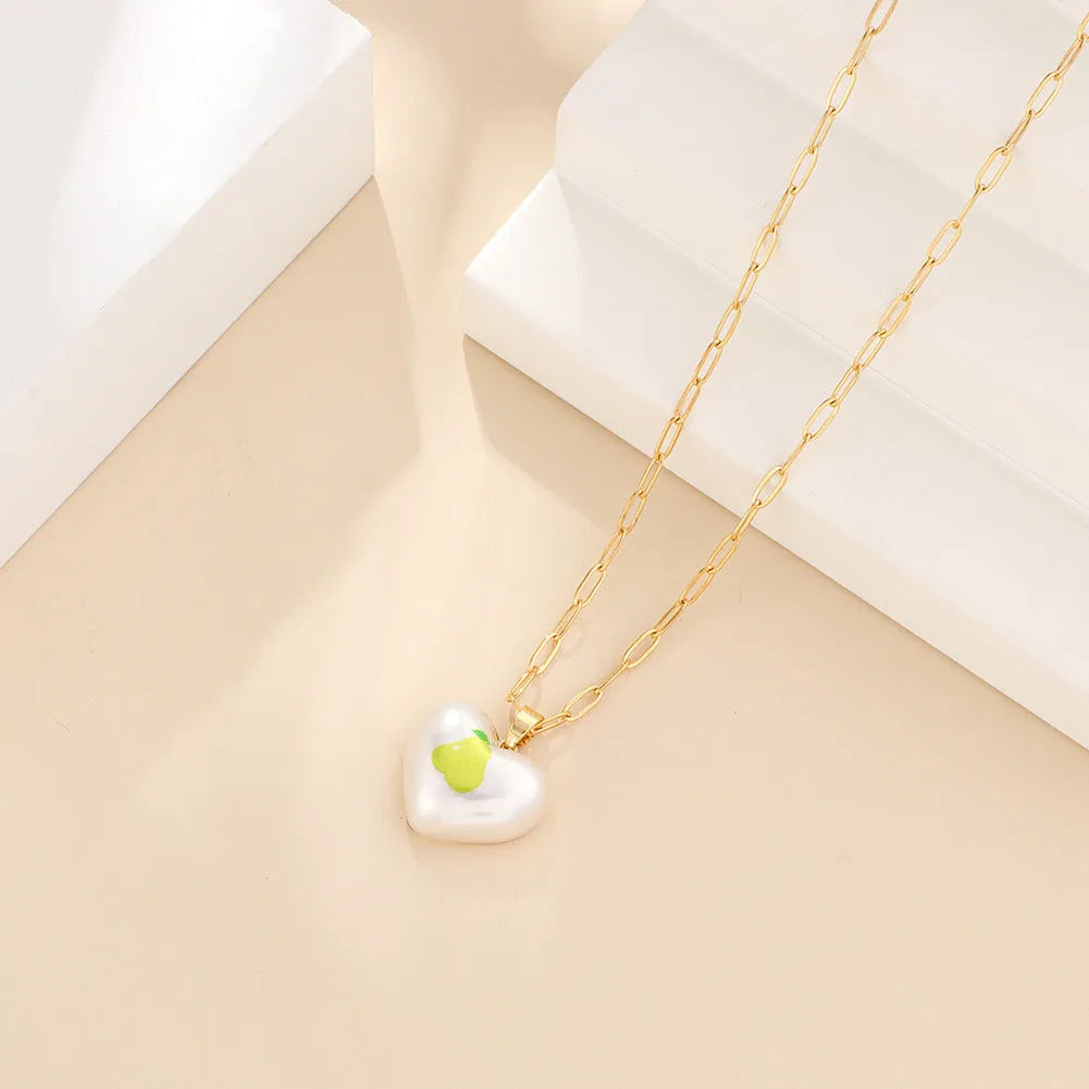 Geometric fruit pendant necklace on an adjustable chain, showing apple, cherry, pear, pineapple, and strawberry charm options.