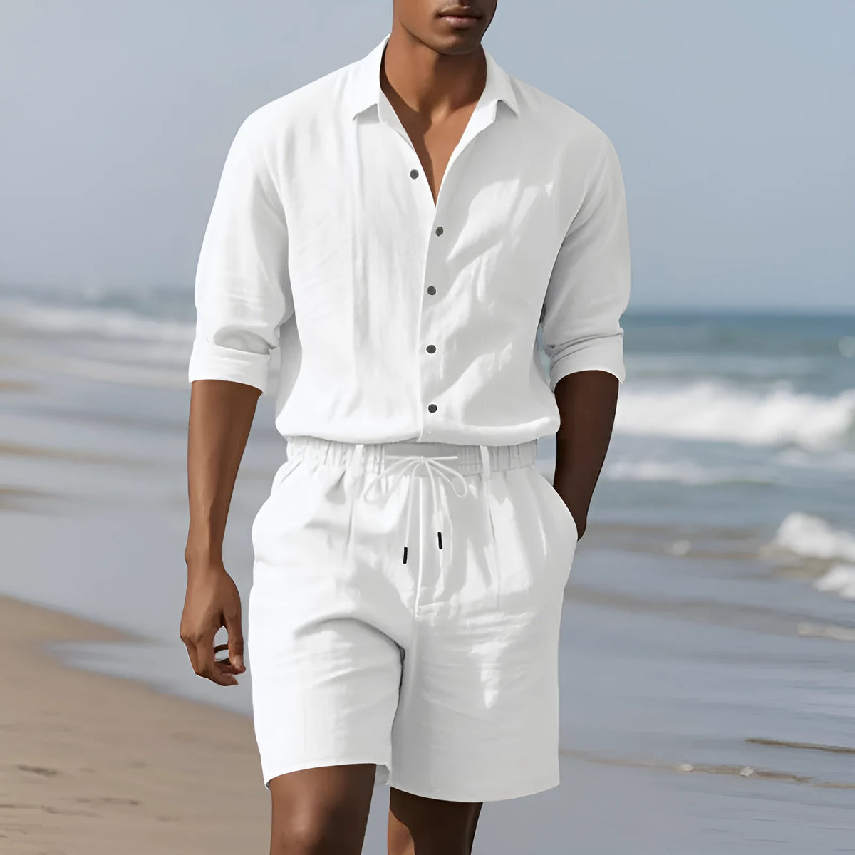 A man wearing a light blue linen long sleeve shirt and matching shorts from the beach suit set.