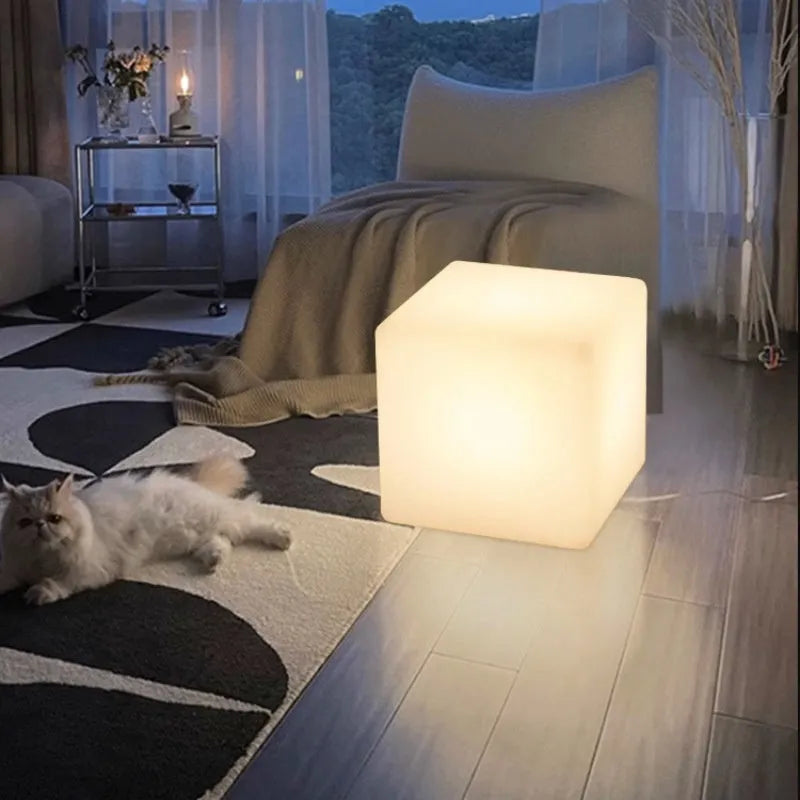A modern square white LED cube stool light for outdoor garden use.