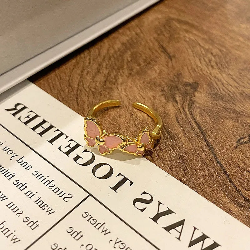 Copper butterfly women's ring with drip oil finish in an open-loop design.