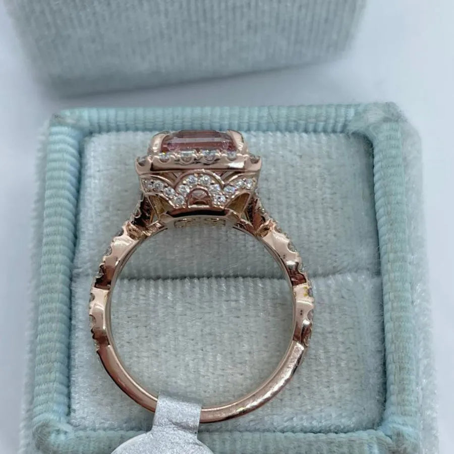 Geometric rose gold coloured alloy ring on a plain background.