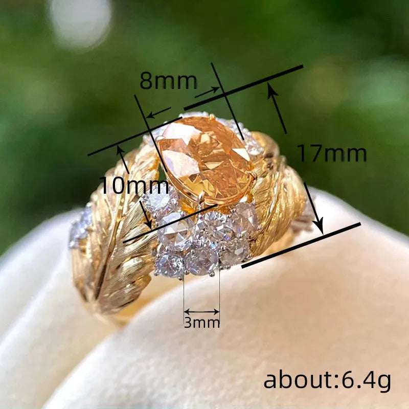 Gold-coloured women's ring with embossed feather pattern and yellow zircon gemstone