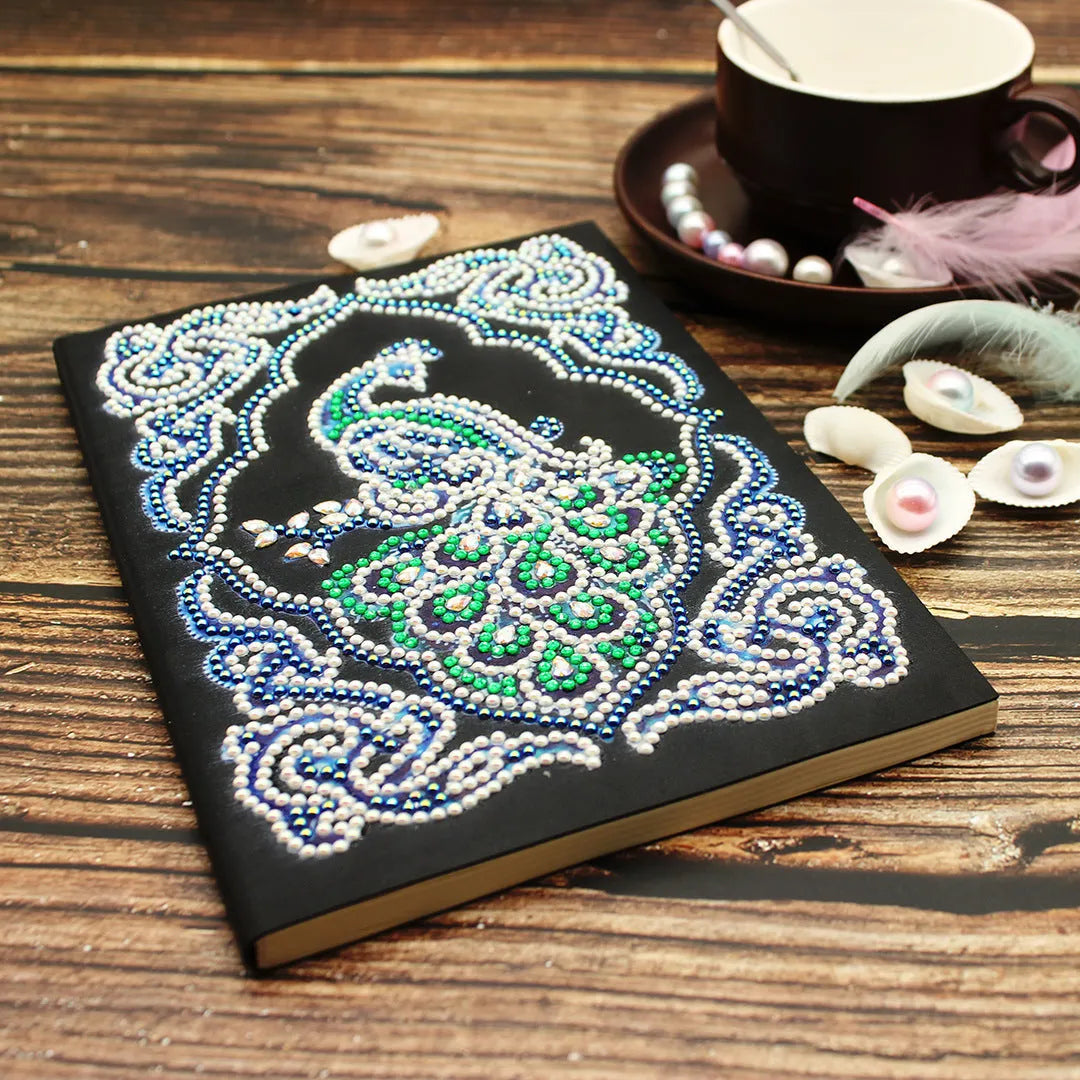 Black A5 diamond painting notebook with shaped and bright rhinestone designs on the cover.