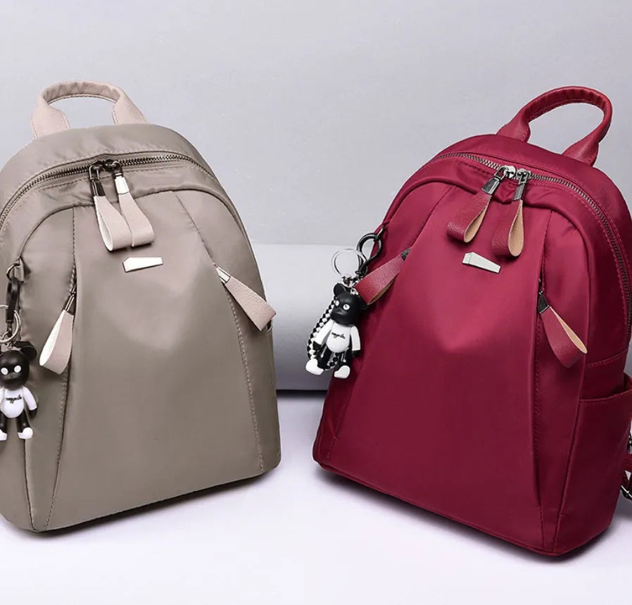 Medium square grey Oxford cloth rucksack with double straps, shown open to reveal internal phone and organiser pockets.