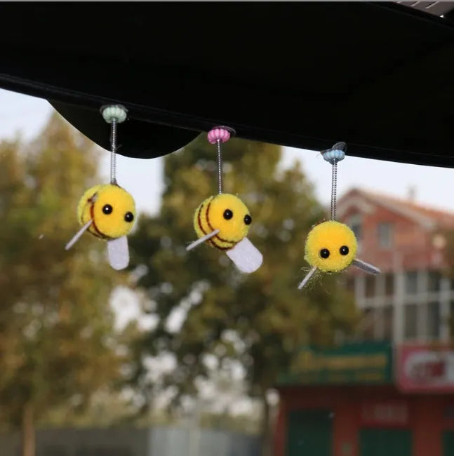 Small plush swing spring bee car decoration ornament on a 3cm scale grid.