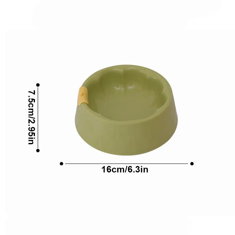 Green plastic flower-shaped double pet bowl for food and water on a white background.