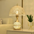 Gold crystal desk lamp with iron art base on wooden bedside table