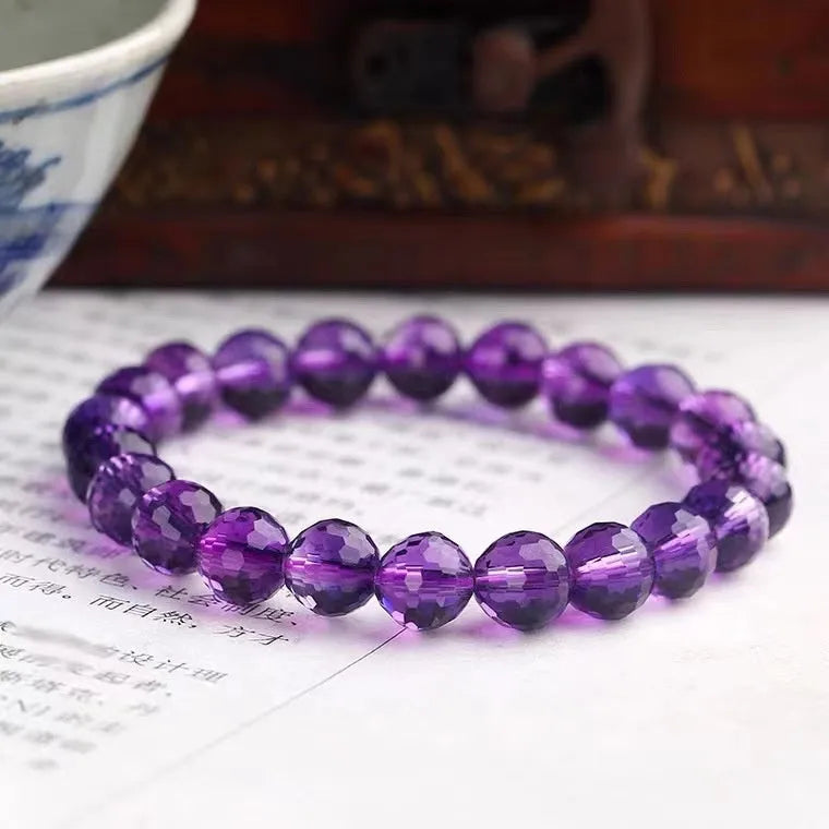 Hand-crafted ametrine bracelet with 128-facet cut crystal beads on a wrist.