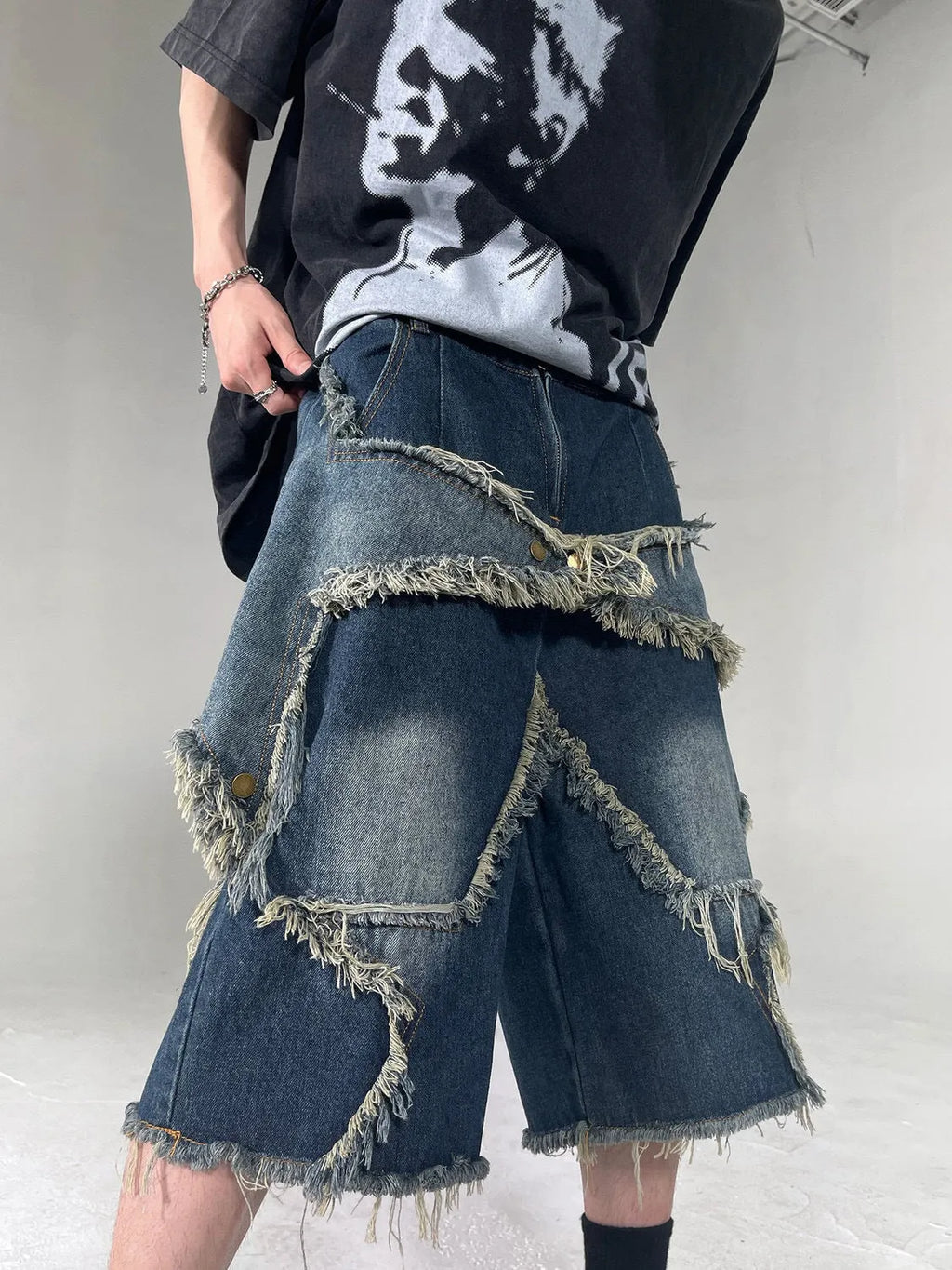 Men's blue retro denim shorts with a frayed five-pointed star design on the leg, showing loose fit.