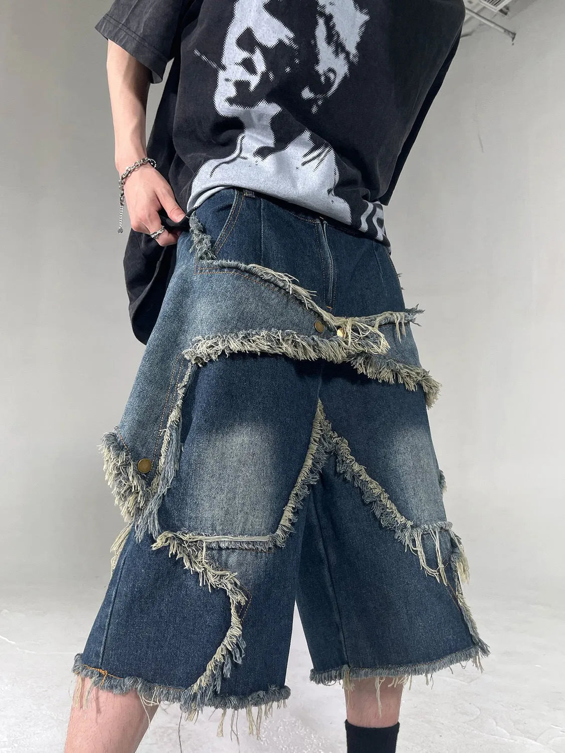 Men's blue retro denim shorts with a frayed five-pointed star design on the leg, showing loose fit.