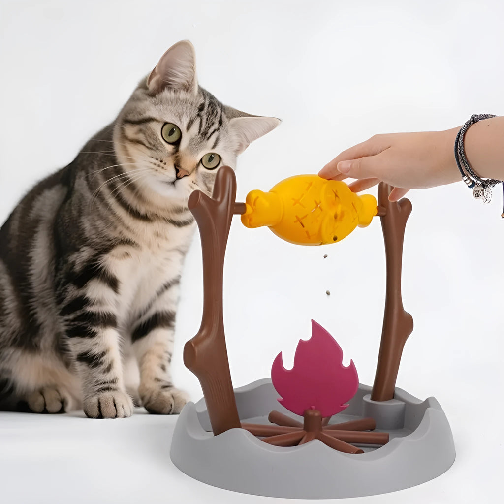 Barbecue style plastic cat toy with tumbling food feeder for treat dispensing.