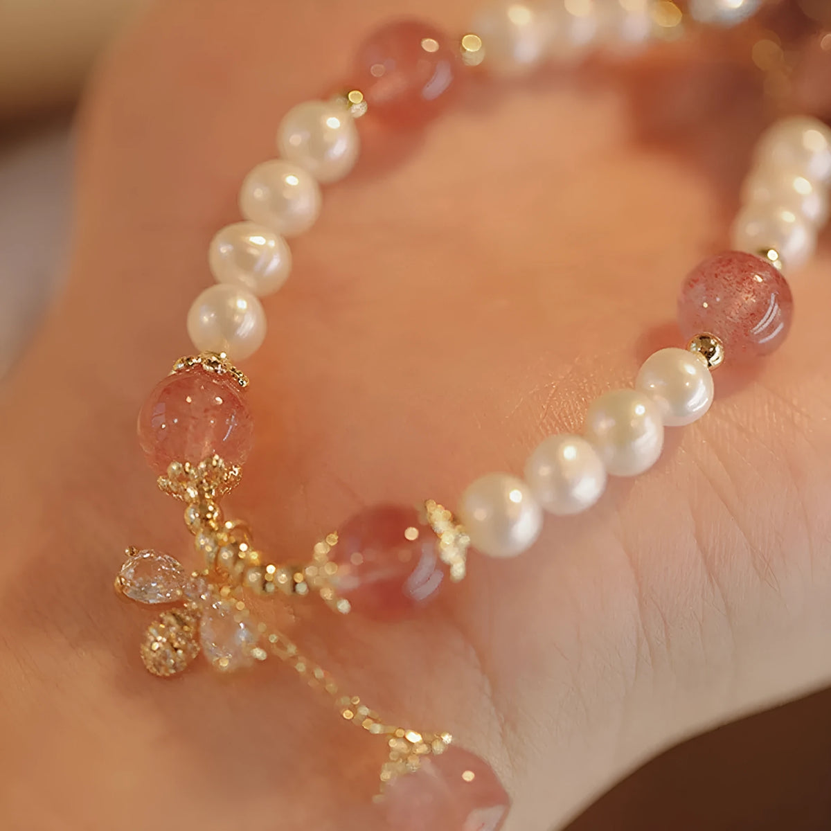 Strawberry quartz crystal bracelet with stringed pearls and bow detail