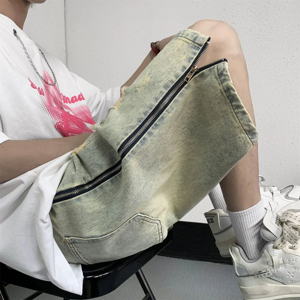 Man wearing blue ripped denim shorts with a yellow mud wash and button-fly closure