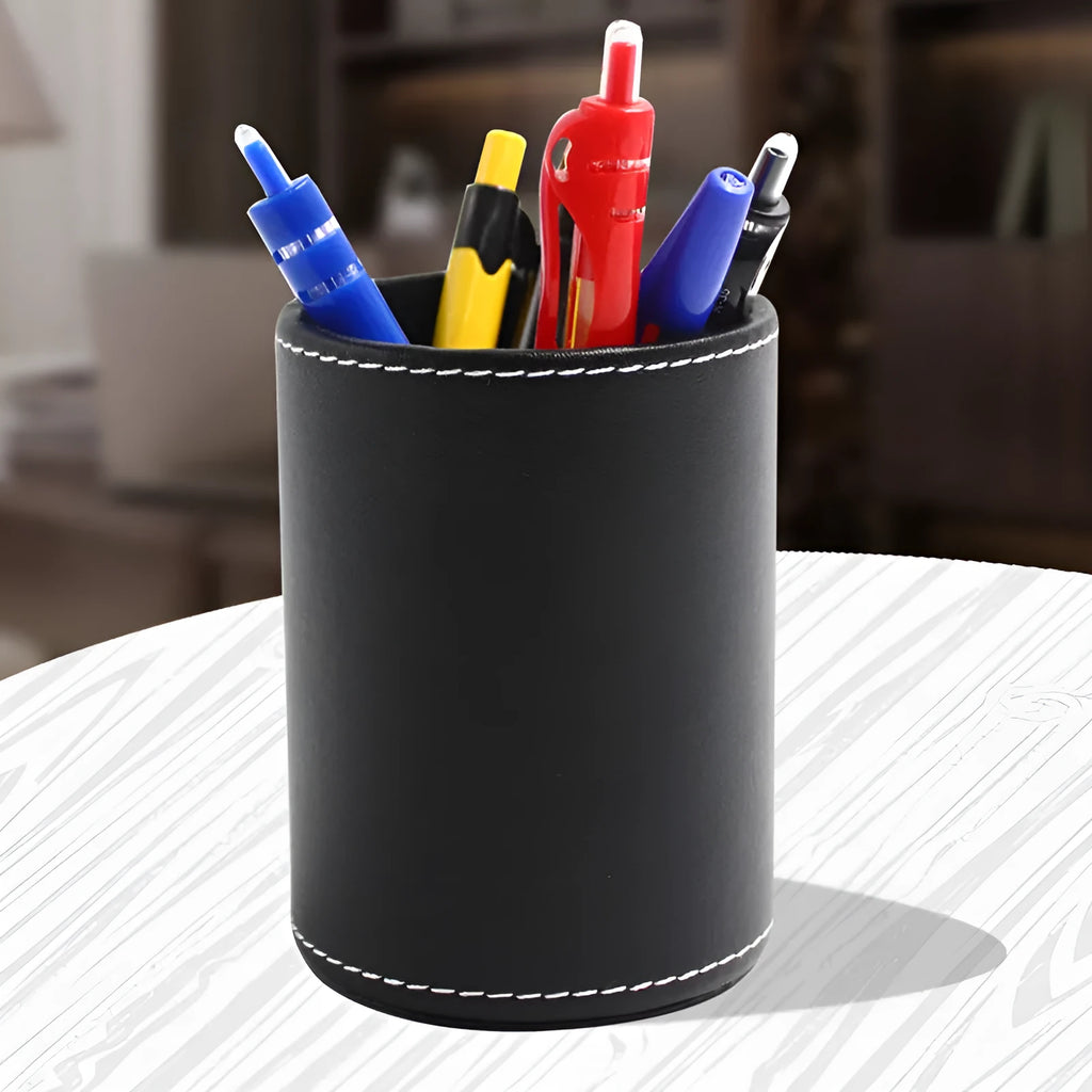 Small round black leather pen holder container on a desk