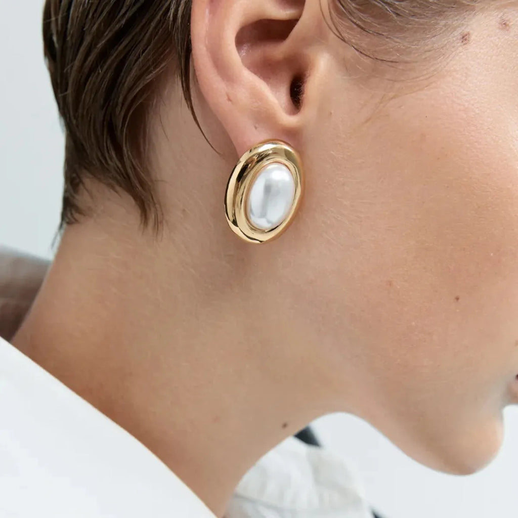 A pair of stainless steel vintage pearl stud earrings with an electroplated silver-coloured finish.