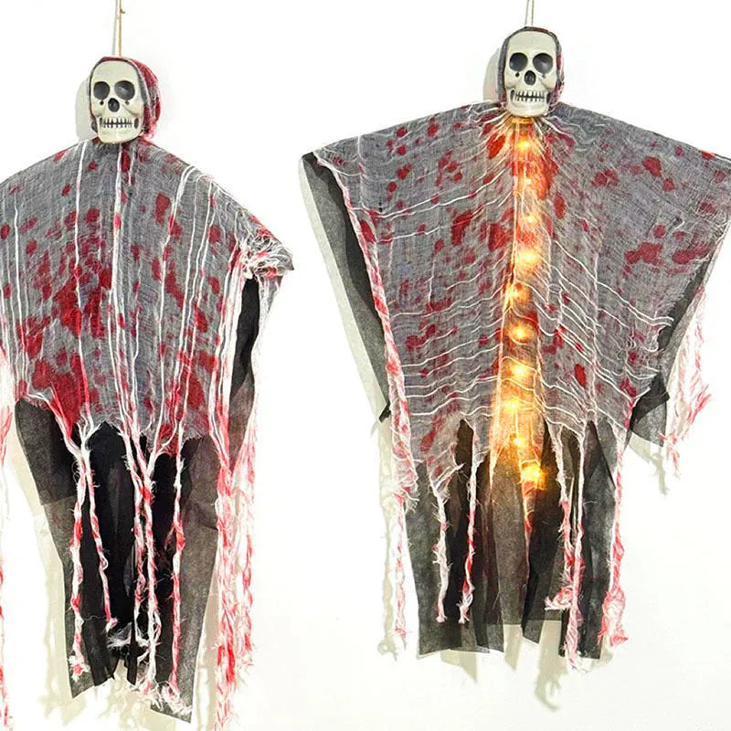 Halloween decoration showing a luminous blood-dyed plastic skull with a hanging ghost outdoor ornament