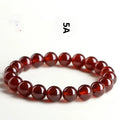 Natural Orange Red Garnet ball bracelet with a Ruyi charm on a white background