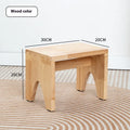 Solid wood changing stool with distressed finish and bracket legs in a living room setting.