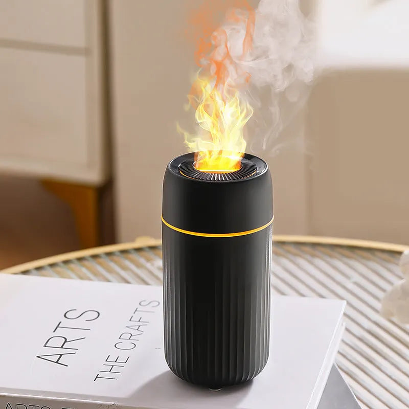 Black car aroma diffuser with simulation flame on a dashboard next to a cup holder.