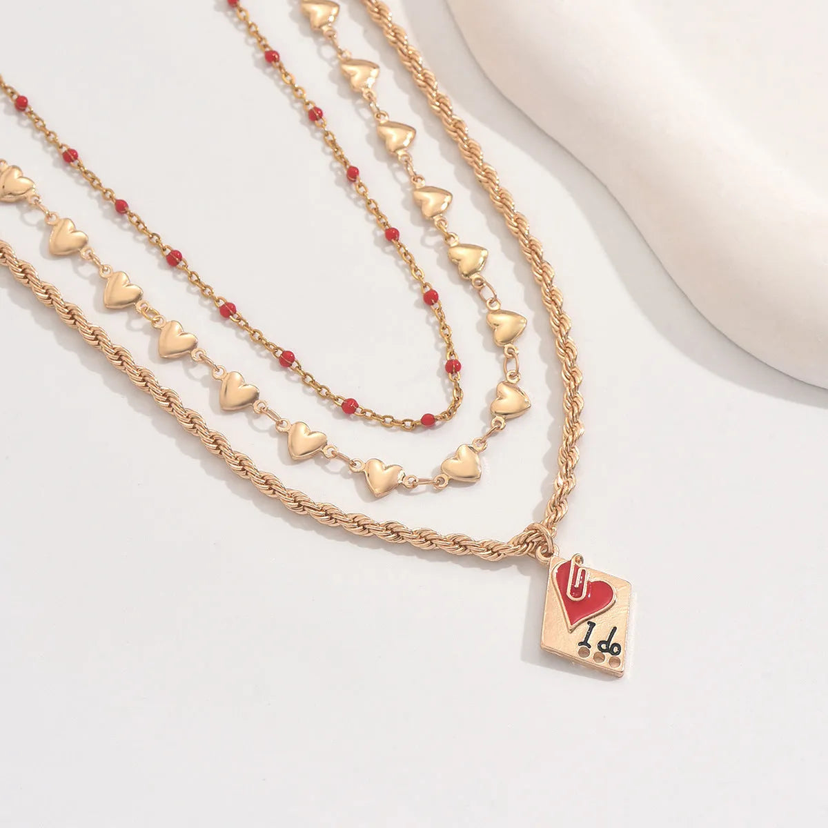 Close-up of a three-layer geometric love pendant on an adjustable zinc alloy clavicle chain.