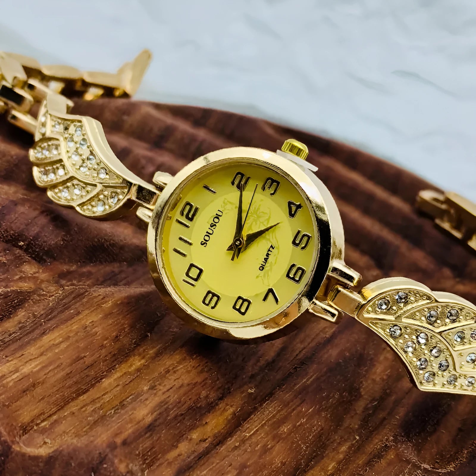 Women's stainless steel watch with round dial showing gold surface, 9mm thickness, and vachette clasp buckle