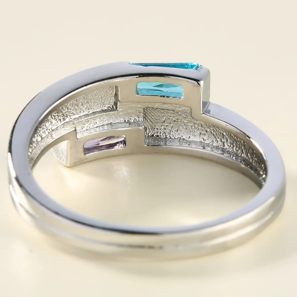Copper ring with inlaid zircon stone in electroplated silver finish on a grey background.