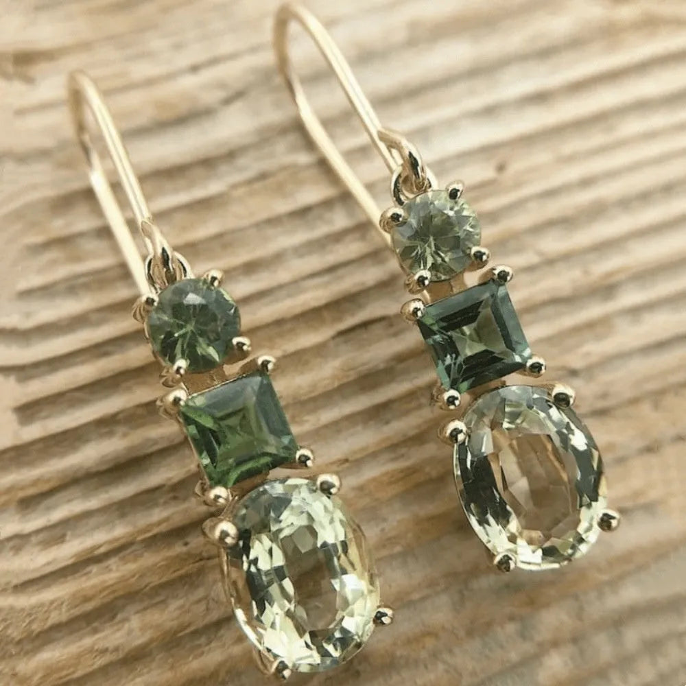 A pair of green square-shaped geometric copper drop earrings on a plain background.