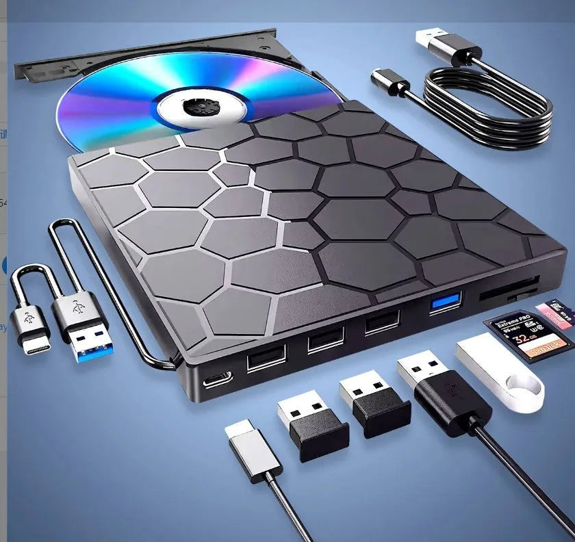 Black external USB CD drive and writer on a desk next to a laptop.