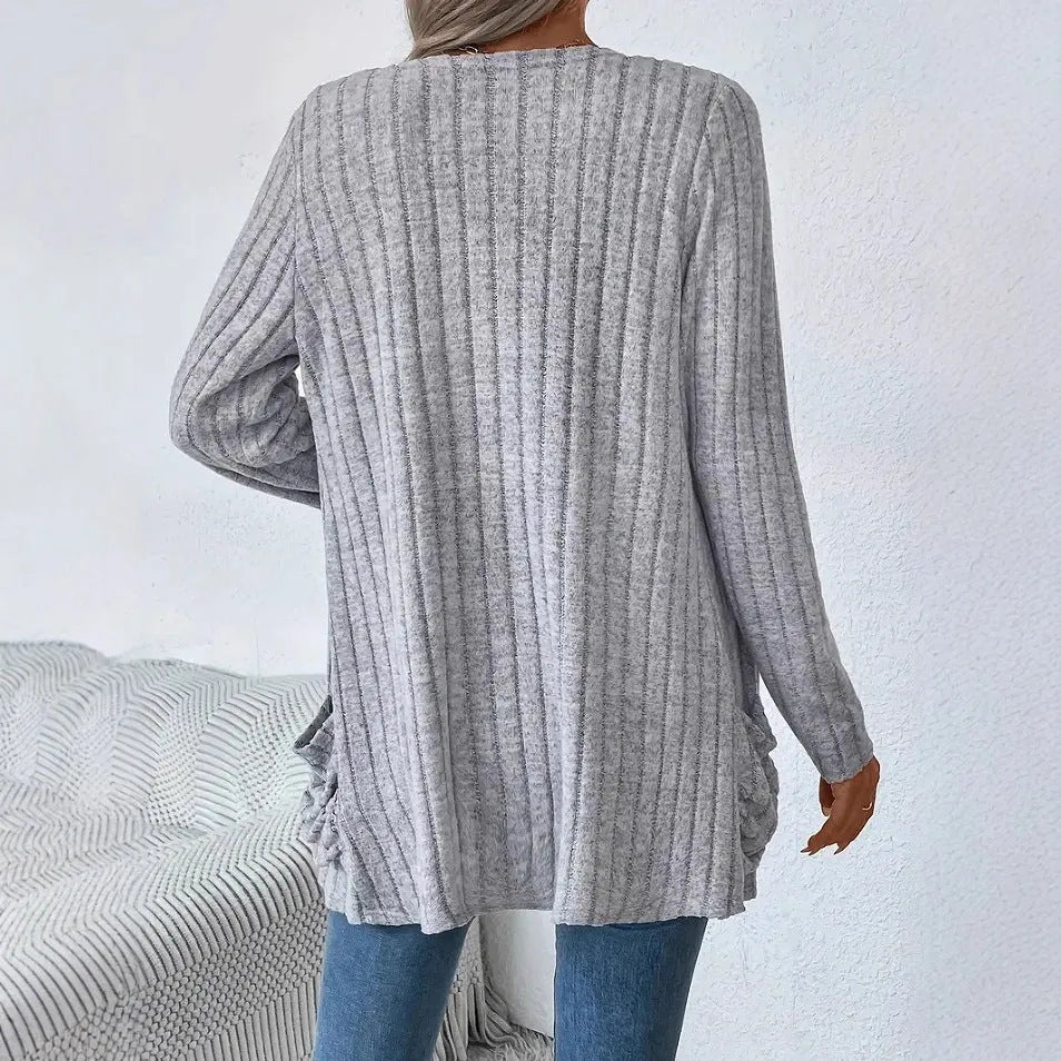 Loose fit grey cardigan with long sleeves and side pockets on a hanger.