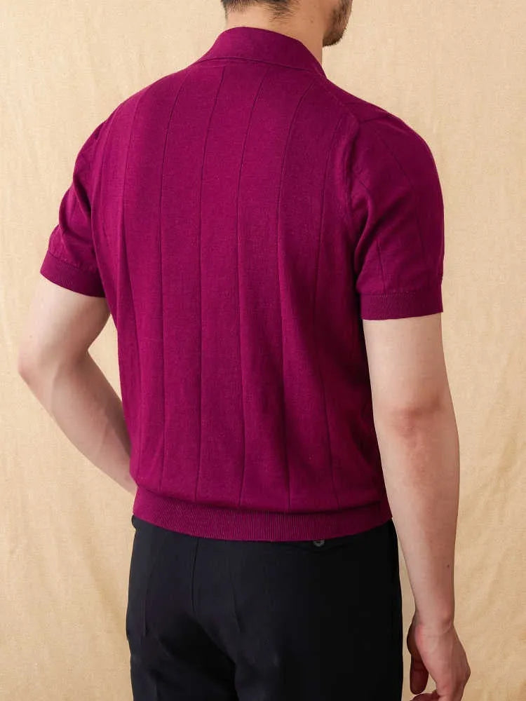 Man wearing a purple knitted short sleeve polo shirt with a seagull collar and sunken stripe pattern.