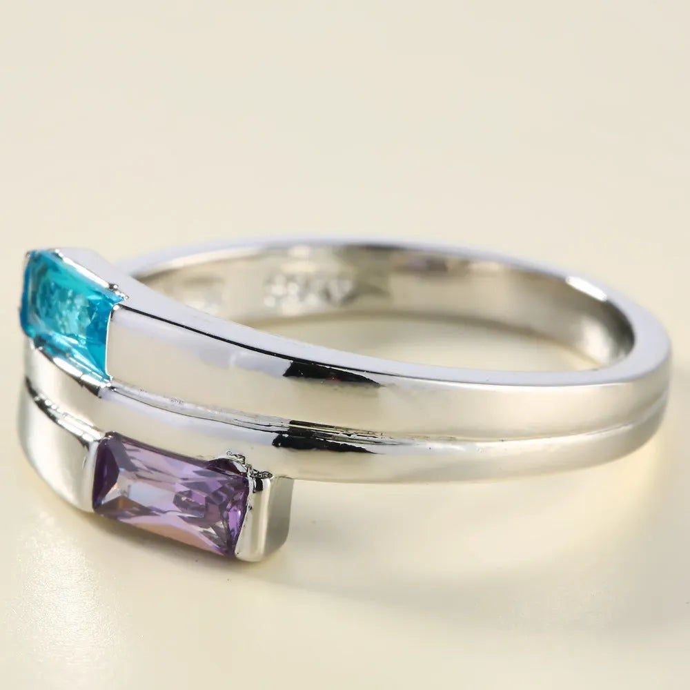 Copper ring with inlaid zircon stone in electroplated silver finish on a grey background.