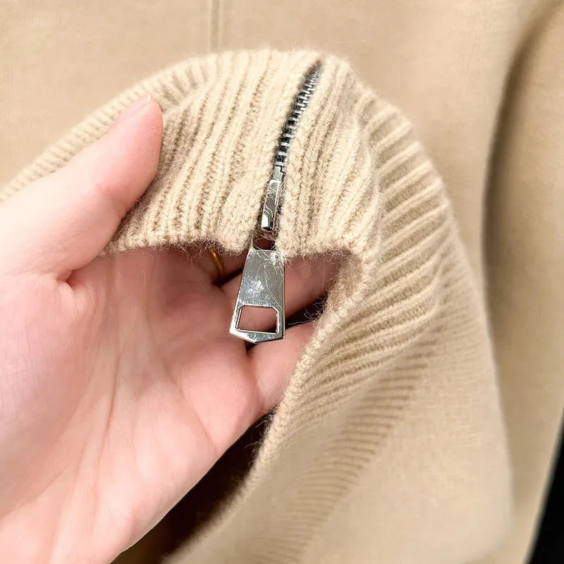 Man wearing a grey, loose-fit, stand collar cardigan with a front zipper.