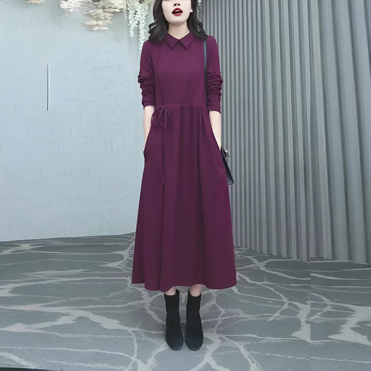 Purplish red plus size long sleeve long skirt dress for women on a hanger.