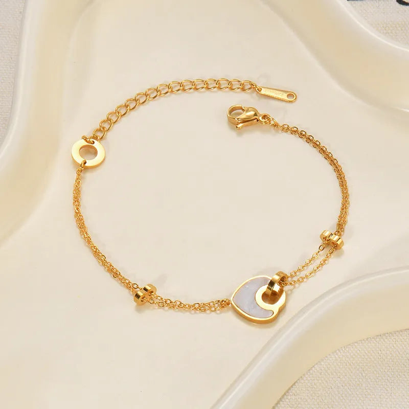 Women's stainless steel bracelet with electroplated finish and a double-layered resin heart charm.