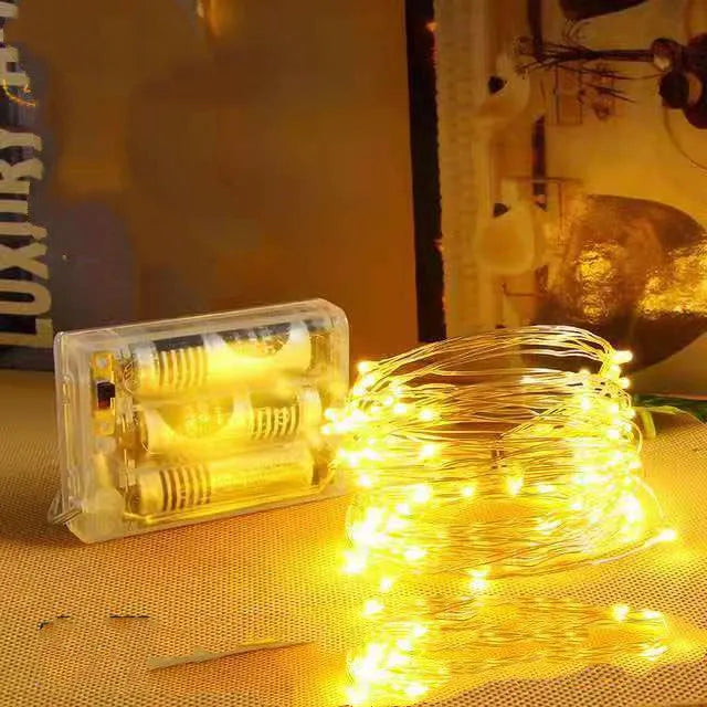 12-metre copper wire LED string lights with 120 bulbs arranged in garden setting