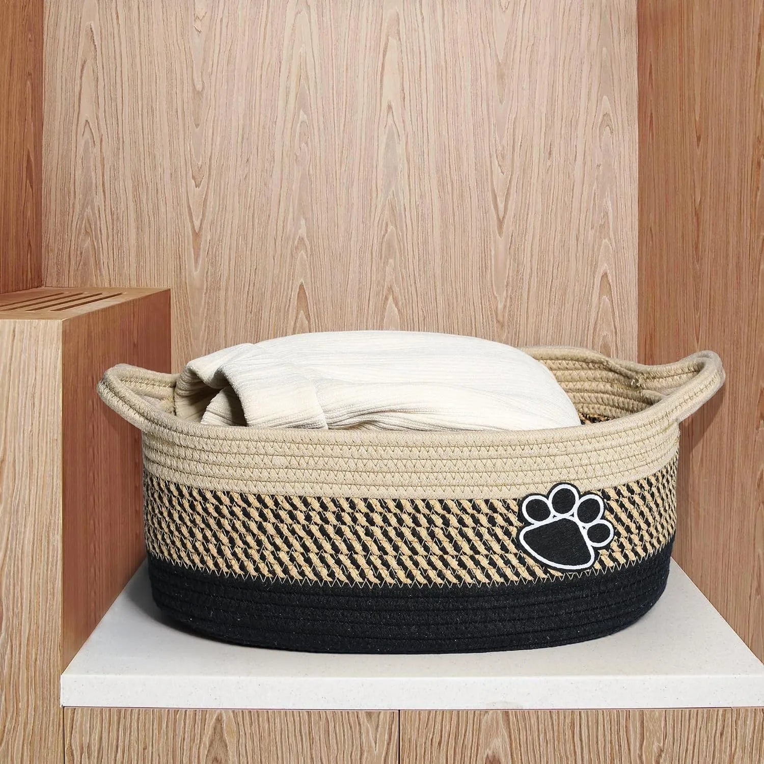 Handmade light beige woven cotton rope storage basket with wood and a handle.