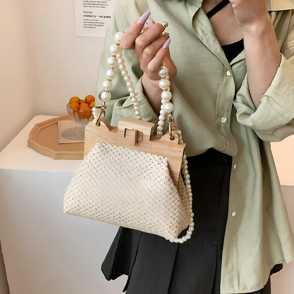Women's straw woven shoulder bag with pearl chain trim showing internal compartments